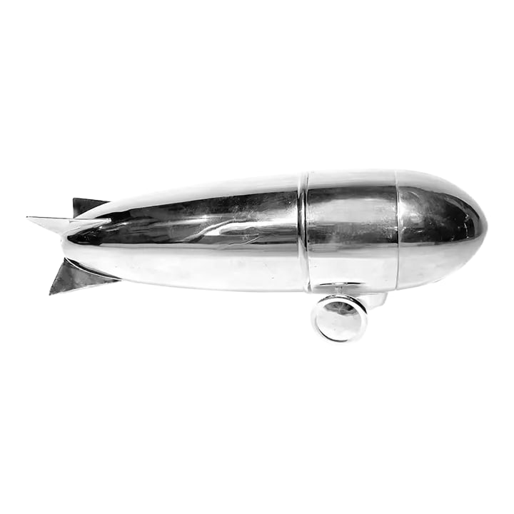 Vintage Art Deco Silver Zeppelin Cocktail Shaker: Three-piece 1910-1950 Art Deco silver-plated zeppelin cocktail shaker. Nose lid, wheel and mid-section strainer lid, and body with tail fins, as the shaker cup. Together the shaker depicts a model