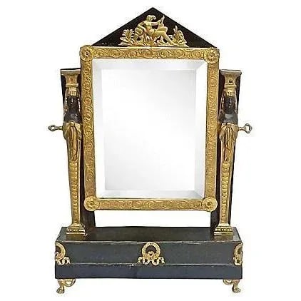 Antique French Empire Vanity Mirror: An antique 19th century French Empire style vanity mirror with adjustable flip mirror with classical accents. The mirror is mounted atop a pressed steel base with brass claw feet and brass wreath