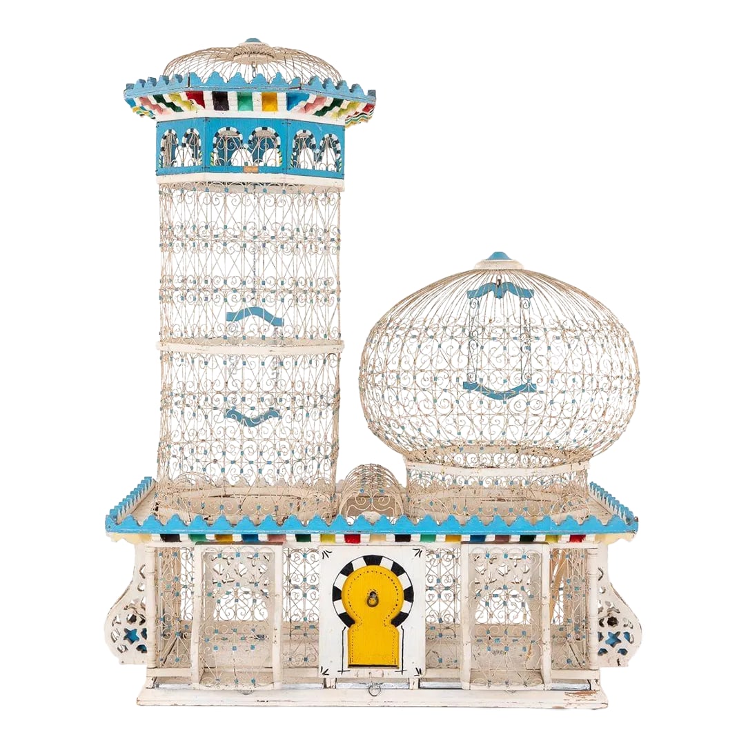Polychrome Wire Birdcage, French 20th-Century: An ornate vintage polychrome wire birdcage featuring a yellow door and two towers. Wooden molding painted in brilliant colors surrounds the crest of the lower level and the taller tower. Each tower
