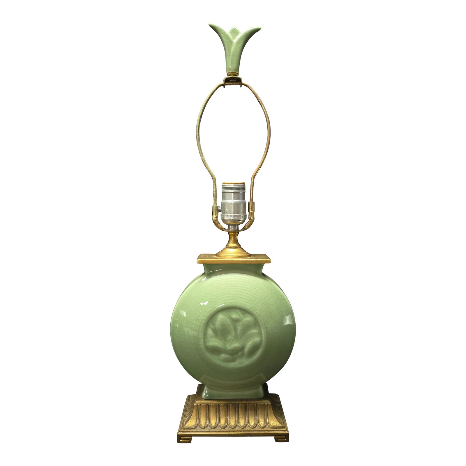Mid-Century Celadon Round Floral Ceramic Table Lamp: This delightful little lamp provides a small pop of color with its soft Celadon green ceramic body, round with a small floral motif in the center and matching celadon three leaf finial. A brass base a