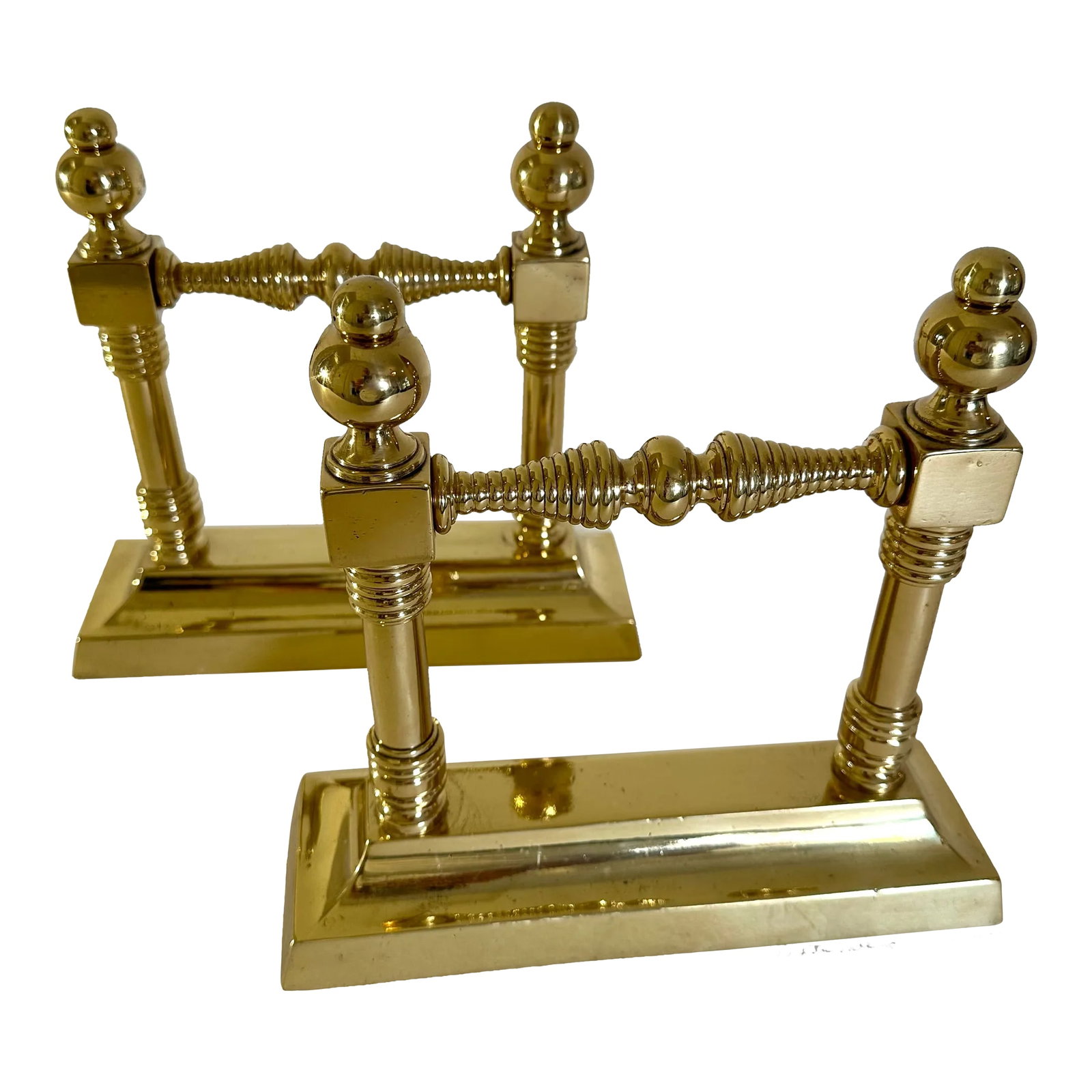 Pair of Late 19th Century British Victorian Brass Fire Dogs: Pair of solid brass Victorian fire dogs with turned bobbin details and rounded finials. Each piece measures 3" W X 9-1/4" L X 8-1/2" H. These pieces have been more recently cleaned and relacquered,