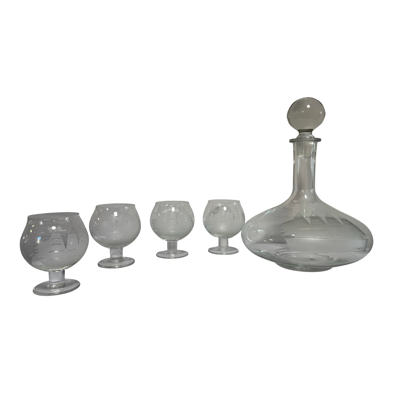 Mid 20th Century European Crystal Brandy Decanter and Snifter Set With Nautical Motif: A refined mid-century European crystal brandy service comprising a sculptural decanter with matching snifters, each decorated with a repeating nautical sailing ship motif. The decoration is executed