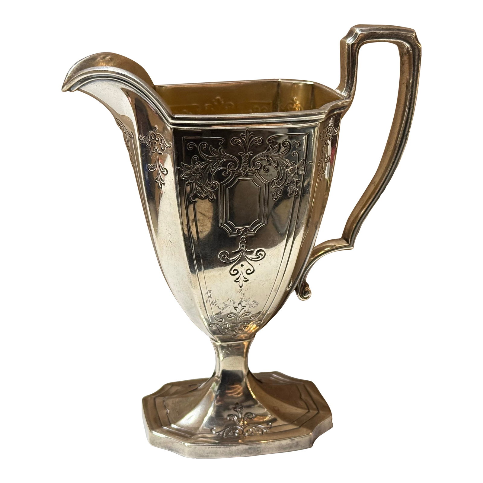 Antique Sterling Silver Creamer Jug With Ornate Handle: This is a antique sterling silver creamer jug. It has intricate carved detailing. It has an ornate handle attached. It has a hexagonal base and it has a spout. It is fabulous. Condition: Alterations: 