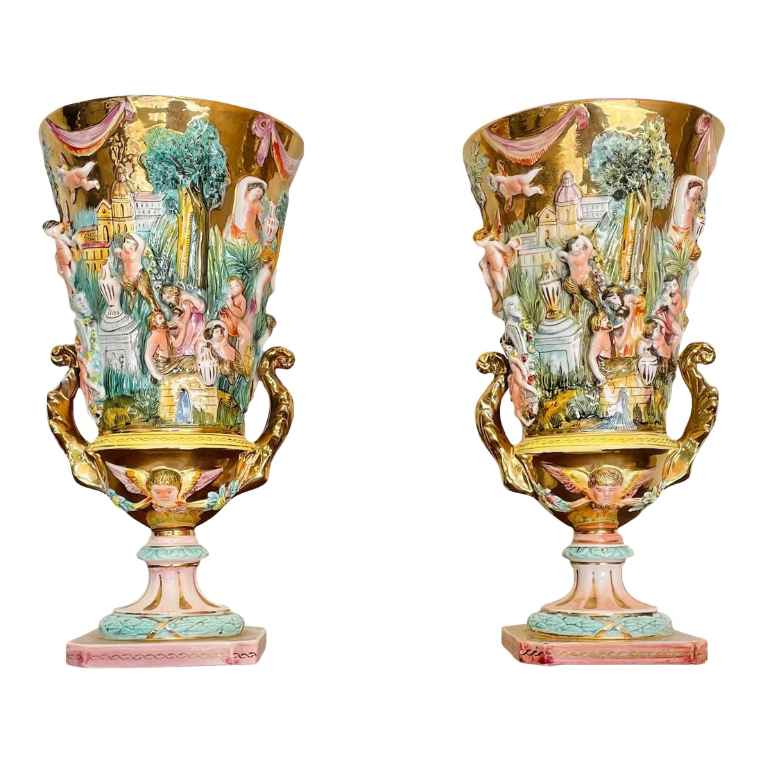 Antique Italian Capodimonte Urns, a Pair: Gold gilded, hand-painted intricate shapes of cherubs, botanicals and ancient structures in a whimsical, high-relief display. These urns or vases embody all of the fine characteristics of the Capodimo