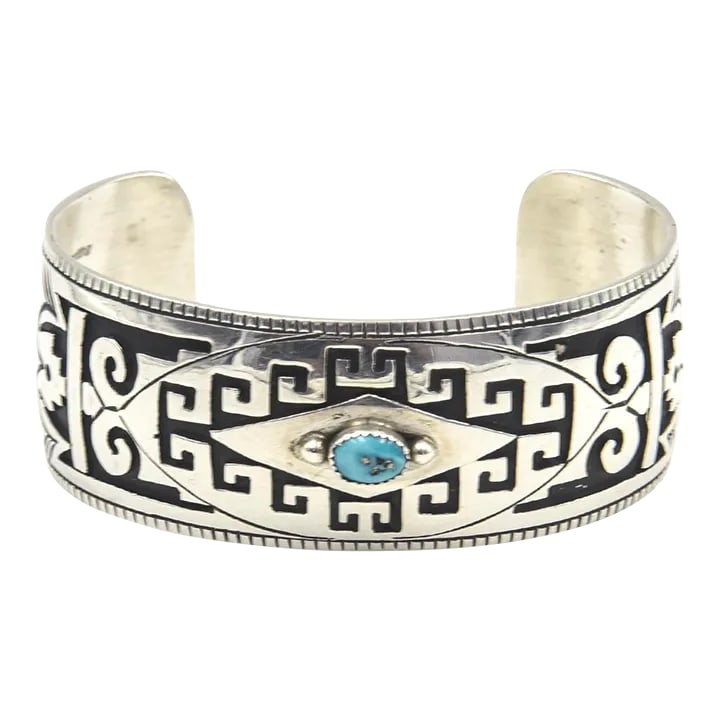 Late 20th Century Native American Turquoise Sterling Silver Cuff Bracelet by Jacob Kahe: This is part of Chairish's Costume Jewelry assortment. Vintage Native American Jacob Kahe cuff bracelet featuring on oval raised turquoise set onto an ornate overlay sterling silver oxidized cuff. Mar