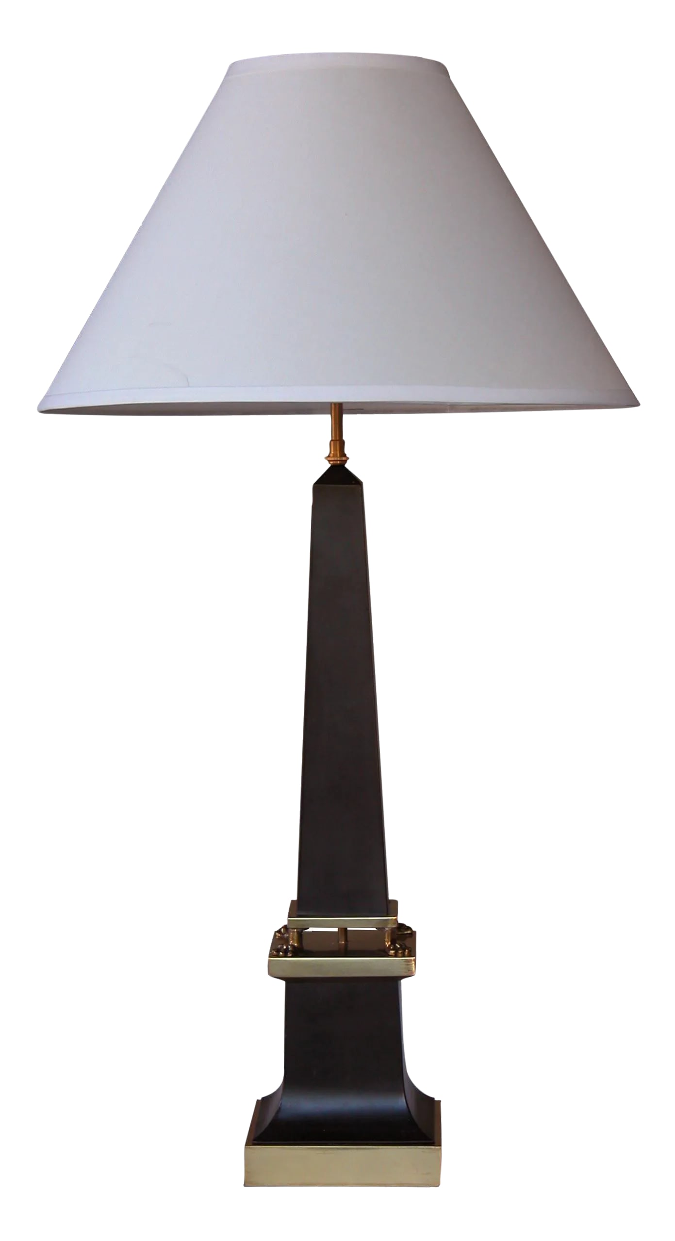 A Sleek French 1940's Black Painted Tole Obelisk-Form Lamp: A sleek French 1940's black painted tole obelisk-form lamp with brass mounts; the graduated obelisk-form body raised on 4 brass paw feet; resting on a splayed base over a brass plinth Condition: