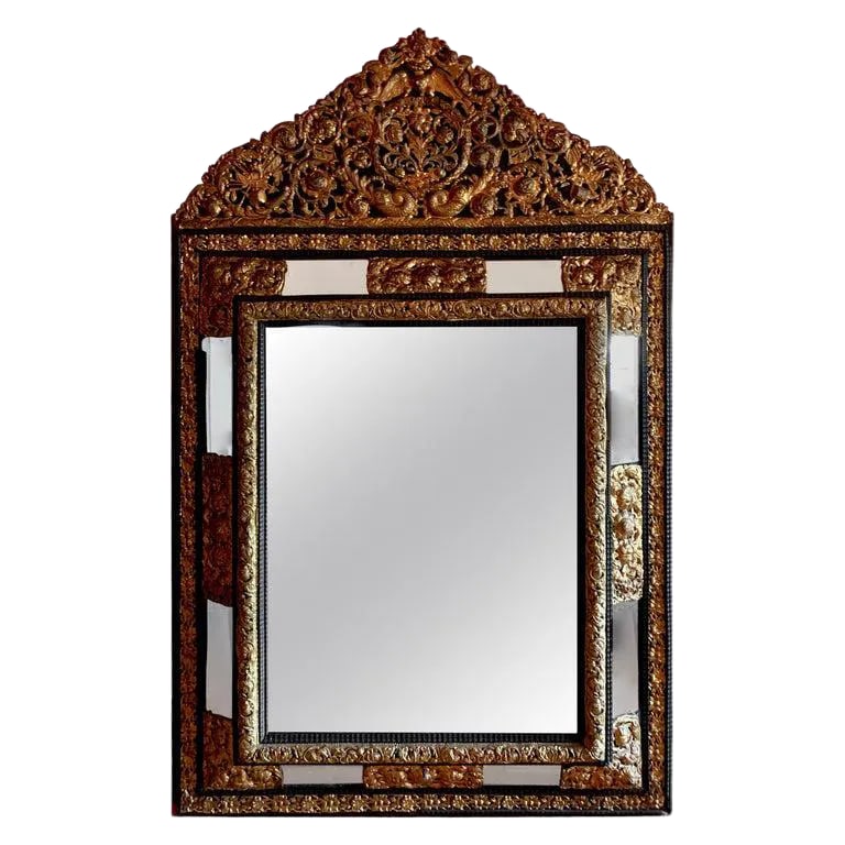 French Ebony Repousse Brass Mirror With Beveled Glass: A monumental, stunning, and beautifully designed French Ebony repousse brass mirror with beveled glass. Hand-hammered with intricate French angels, drums. A very substantial and important look. The mi