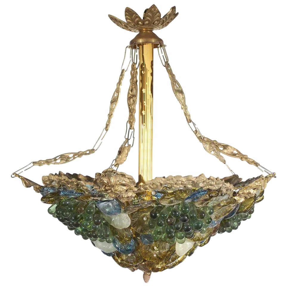 Art Deco Art Glass & Brass Chandelier: This colorful art glass and brass chandelier is from an earlier part of the last century. The brass frame is supported by a central column and four chains. Art glass grapes and flowers are attached