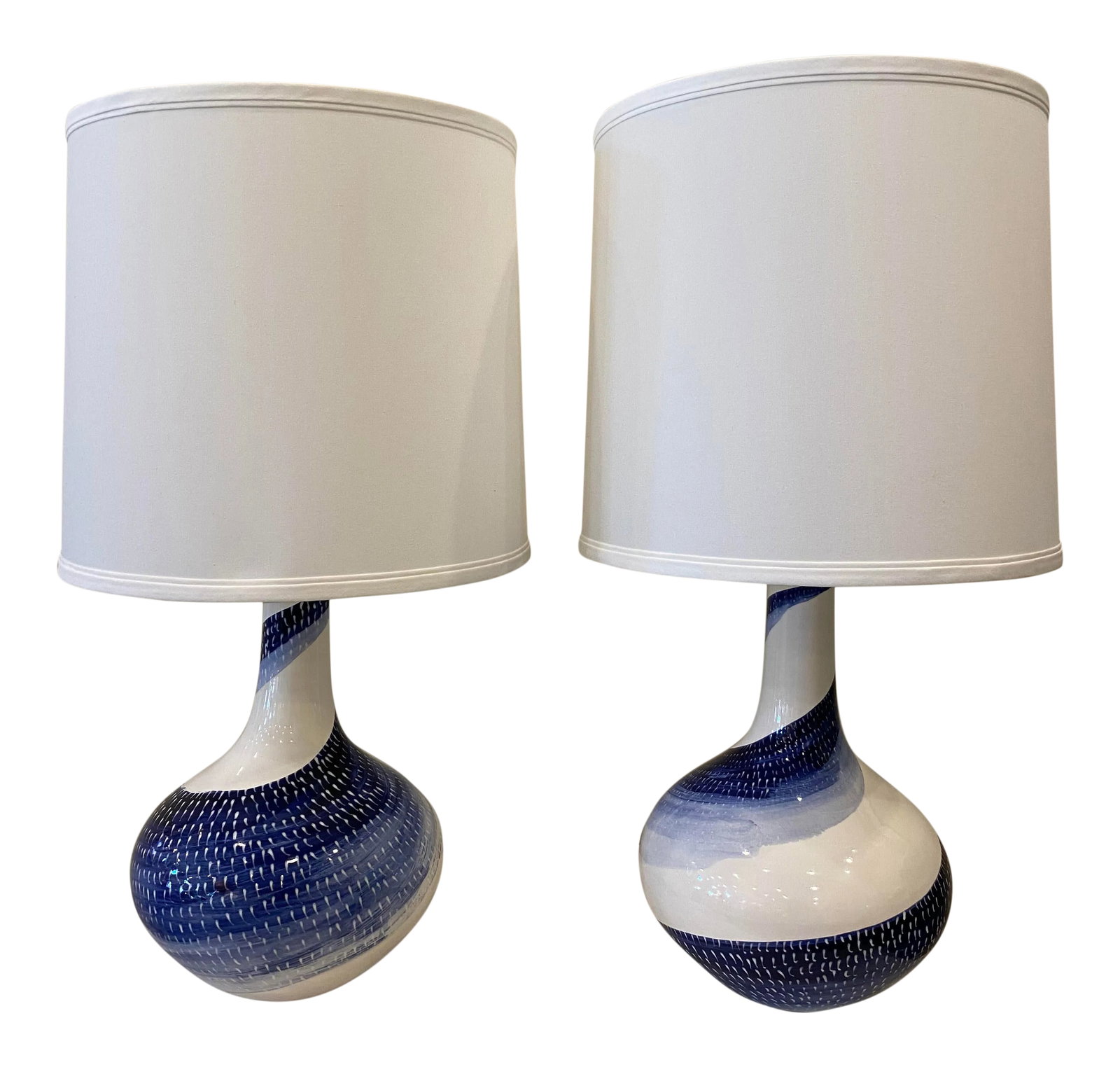 Blue and White Ceramic Lamps- a Pair: This is a unique pair of blue and white lamps. They are hand sculpted and hand painted giving them wonderful character. The style would blend well in an design aesthetic from traditional to