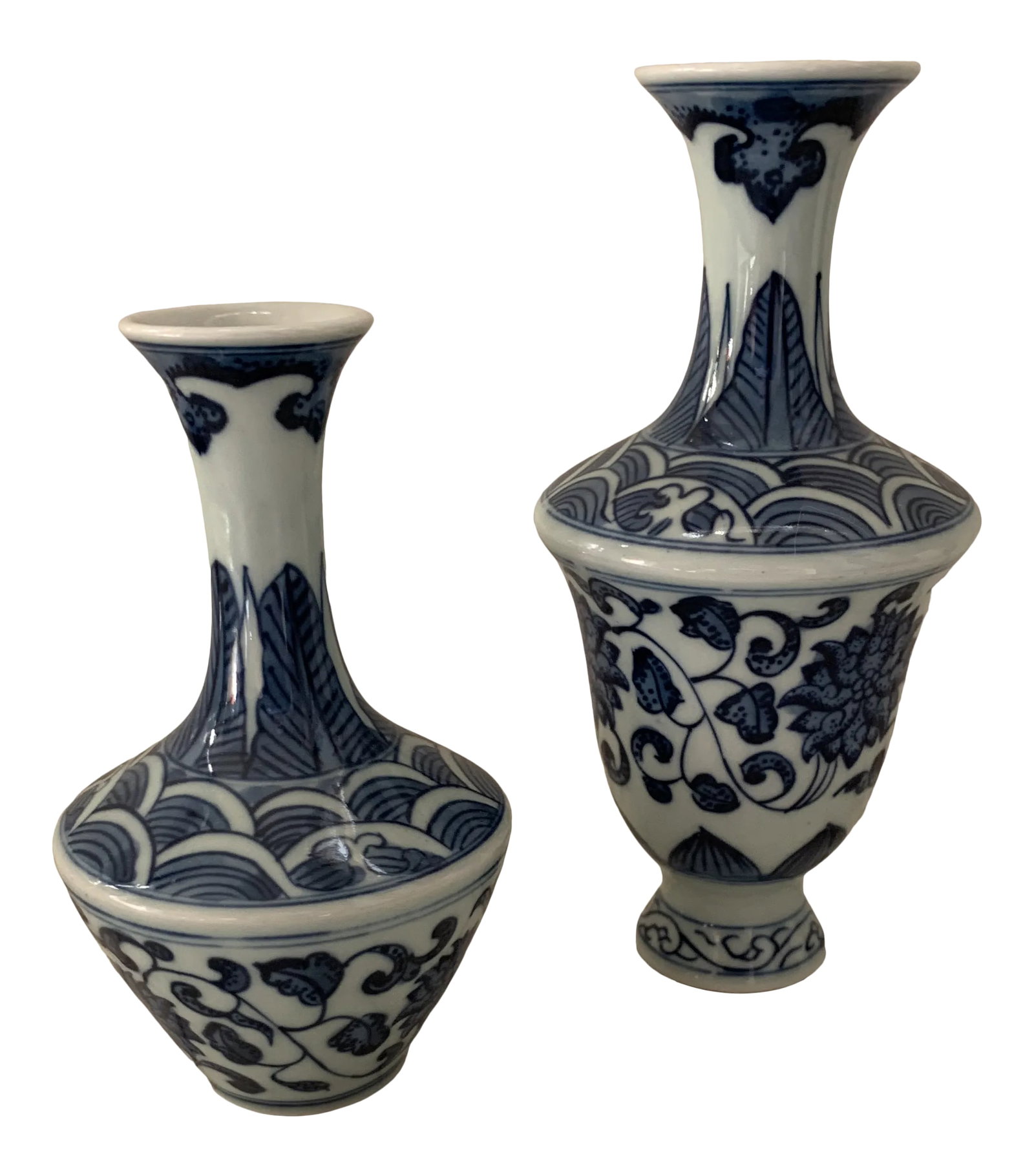 Blue & White Porcelain Chinoiserie Vases Pair: A curated pair of small Chinese vases with floral blue-and-white chinoiserie transfer pattern. Artist stamp on underside. Measurement is for the tallest vase. Shortest vase measures 4.5"H x 3" x 3". C