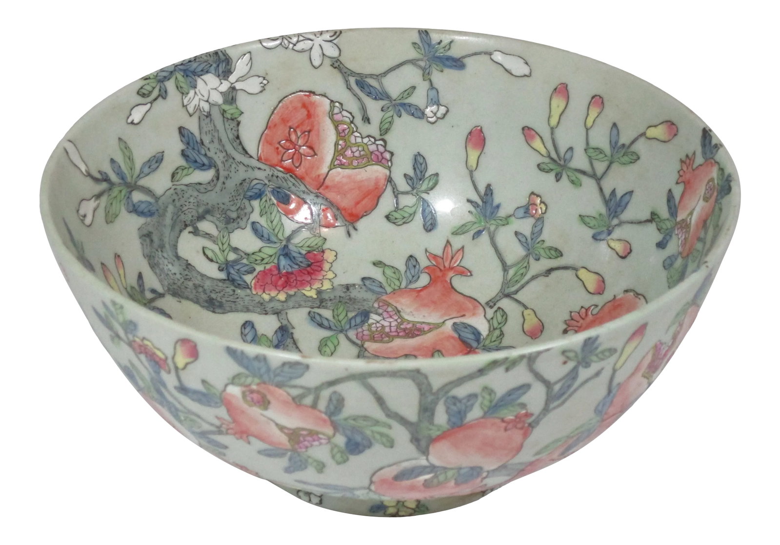 Vintage 1980s Chinese Pomegranate Bowl: A large vintage porcelain hand painted Chinese bowl. This enamel painted bowl has a celadon background with all over designs of branches of peach pomegranates and flowers with green leaves. It would