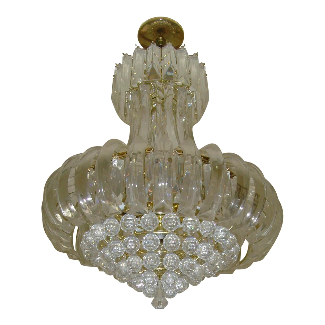 1970s Contemporary Lucite and Metal Chandelier: Featured is a six-tiered lucite chandelier with a gold-tone metal base. Measuring approximately 28 inches tall by 20 inches wide, the fixture houses a total of 10 lights. I believe it may date back