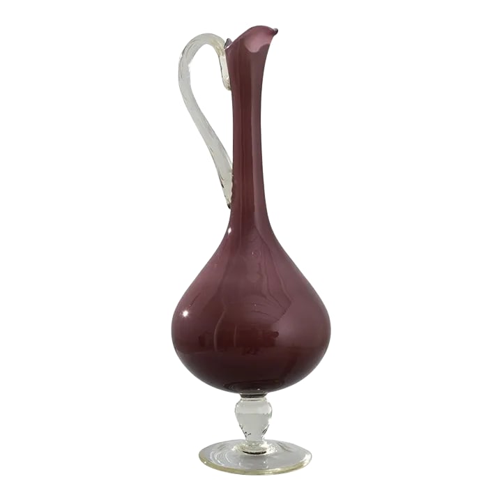 1960s Italian Clinker Red Glass Pitcher: Romantic and striking, this glass vase offers a unique vintage accent. Made in Italy in the 1960s, the shape is elegant and piercing: a slender handle gracefully merges with the colored glass vessel.