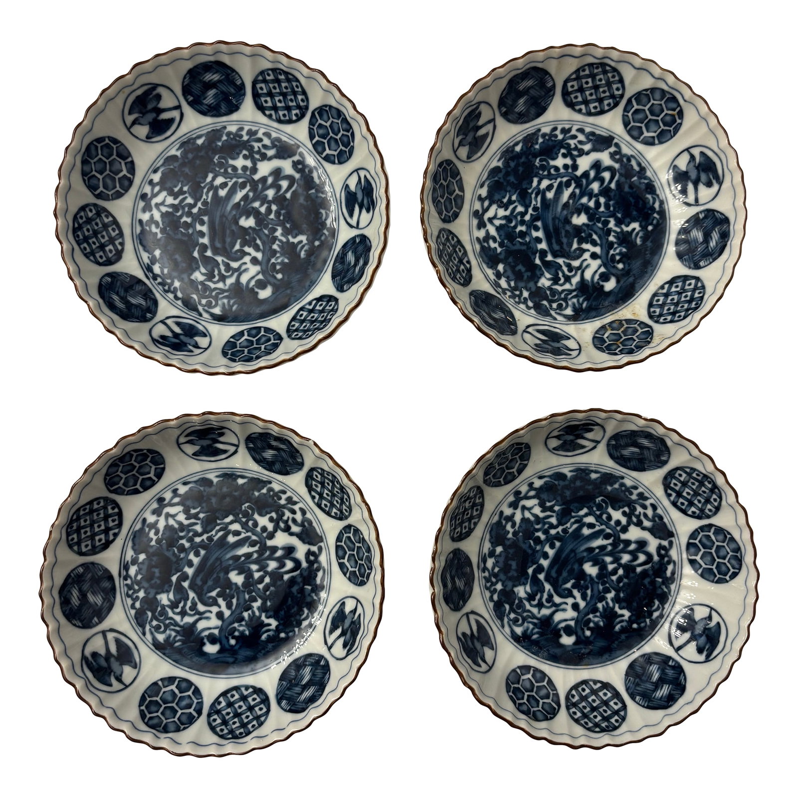 Early 19th Century Set of Four Ching Te Chen Style Blue and White Phoenix Salad Plates: These are International Ching Te Chen salad plates. It features a blue and white design with a central bird (likely a phoenix) pattern and a blue medallion edge. The plate has a scalloped edge. It is 
