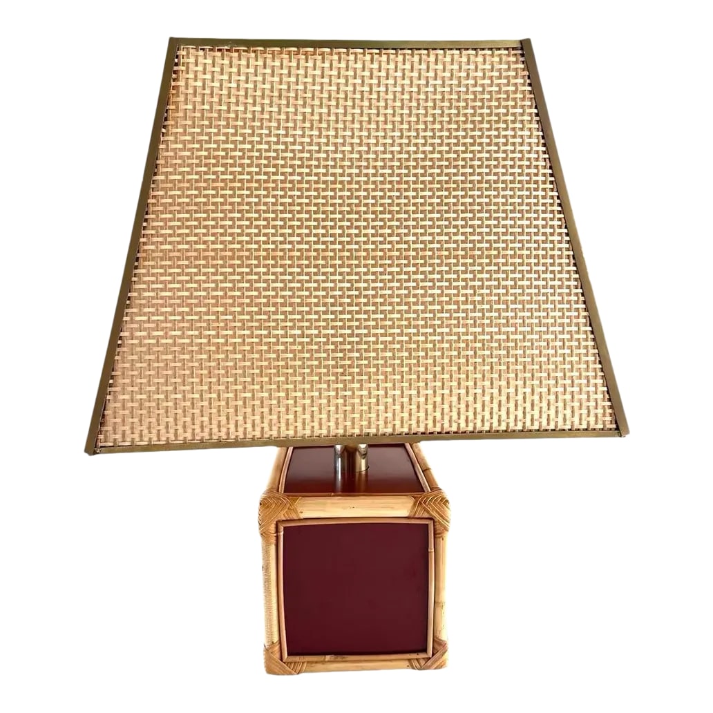 Signed French Bamboo Rattan Oxblood Lamp W"Shade: Vintage 1960's French signed lamp. Bamboo rattan edges over lacquered oxblood burgundy sides. Woven trapezoid shade with brass edges. Shade measures 18" wide x 14" deep x 14" tall. Base measures 9"x8"