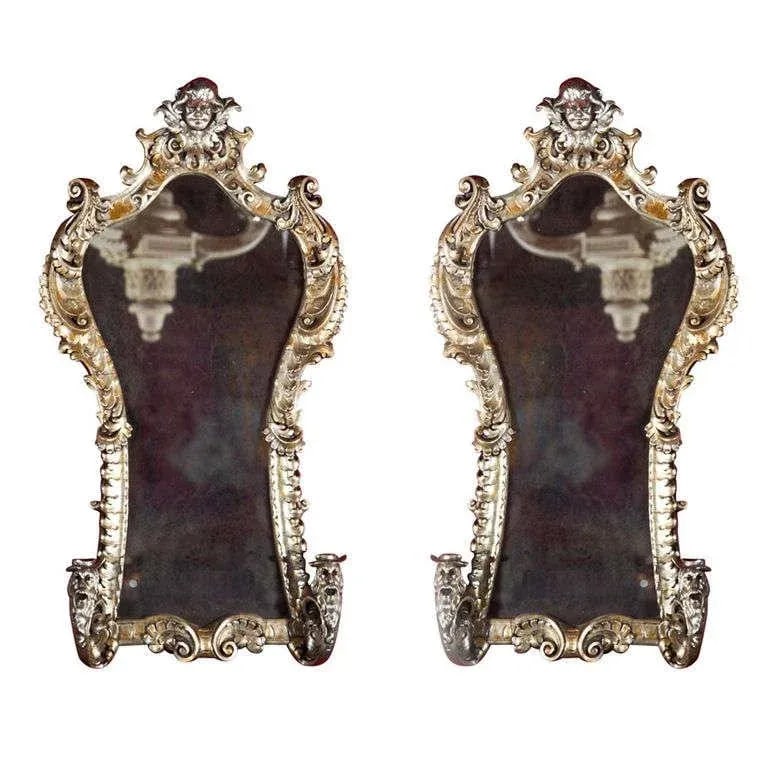 French Rococo Style Mirrored Sconces, Pair: Pair of French Rococo style girandoles, late 19th century. Feature a fine silver-gilt and are elegantly decorated with figural and scrolls. Include two candlestick-arms. Condition: Alterations:
