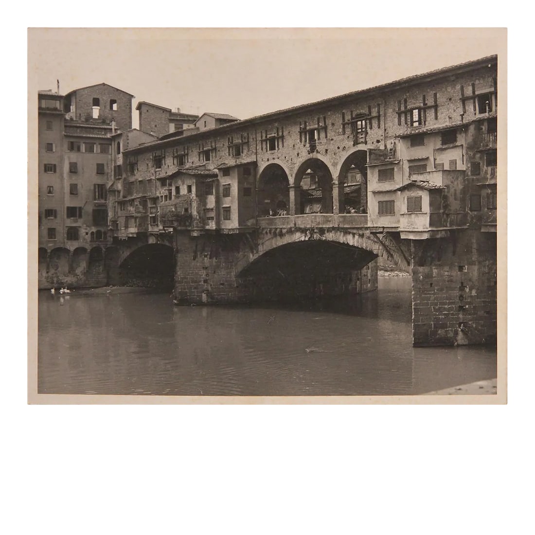 Ponte Vecchio Bridge in Florence, Italy Black and White Photograph: The Ponte Vecchio is a medieval stone closed-spandrel segmental arch bridge over the Arno River, in Florence, Italy. It is noted for the shops built along it, as was once common. The photograph is