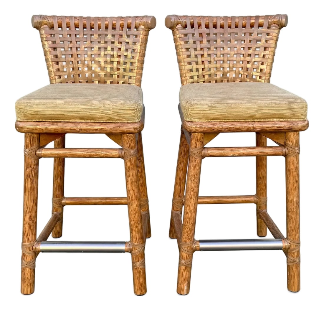 Pair of Vintage McGuire Woven Rattan and Rawhide Counter Height Bar Stools: Presenting a beautiful pair of vintage stools by the renowned McGuire Furniture Company, epitomizing relaxed California elegance. These well crafted seats feature a distinctive woven rattan basket-wea