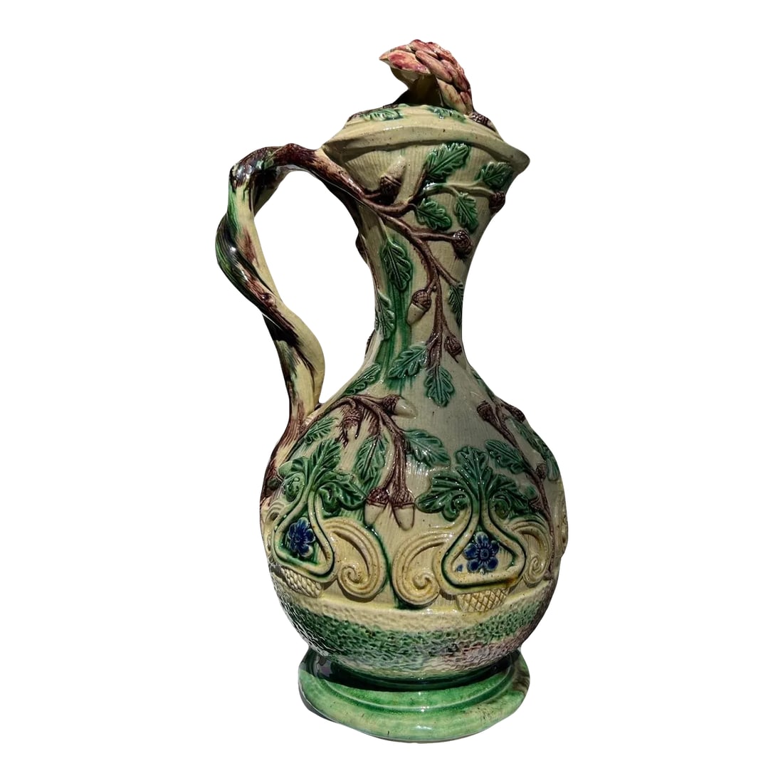 19th Century, Faux Bois Majolica Ewer W/ Acorn & Foliate Design: Continental, 19th century. A finely detailed continental majolica or palissy ware pitcher. The ewer has hand applied foliate and acorn motifs the body. The handle constructed of an intertwining tree b