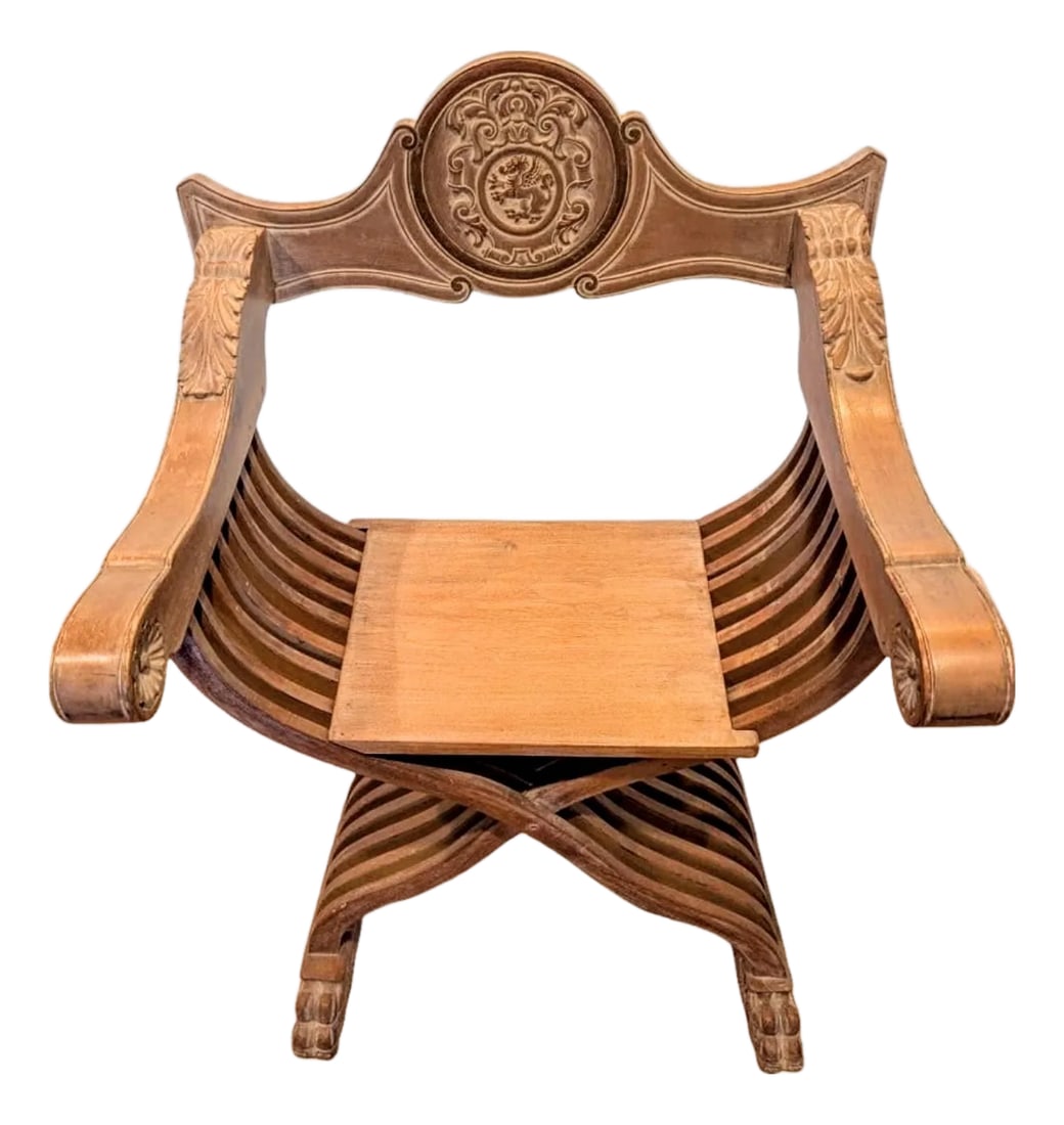 Mid 20th Century Carved Wood Savonarola Chair With Asian Crest on Backrest: This piece is in the style of an iconic 15th-century Italian Renaissance folding chair characterized by an "X" or "scissors" frame made of multiple, curved wooden slats. This chair is a reproduction