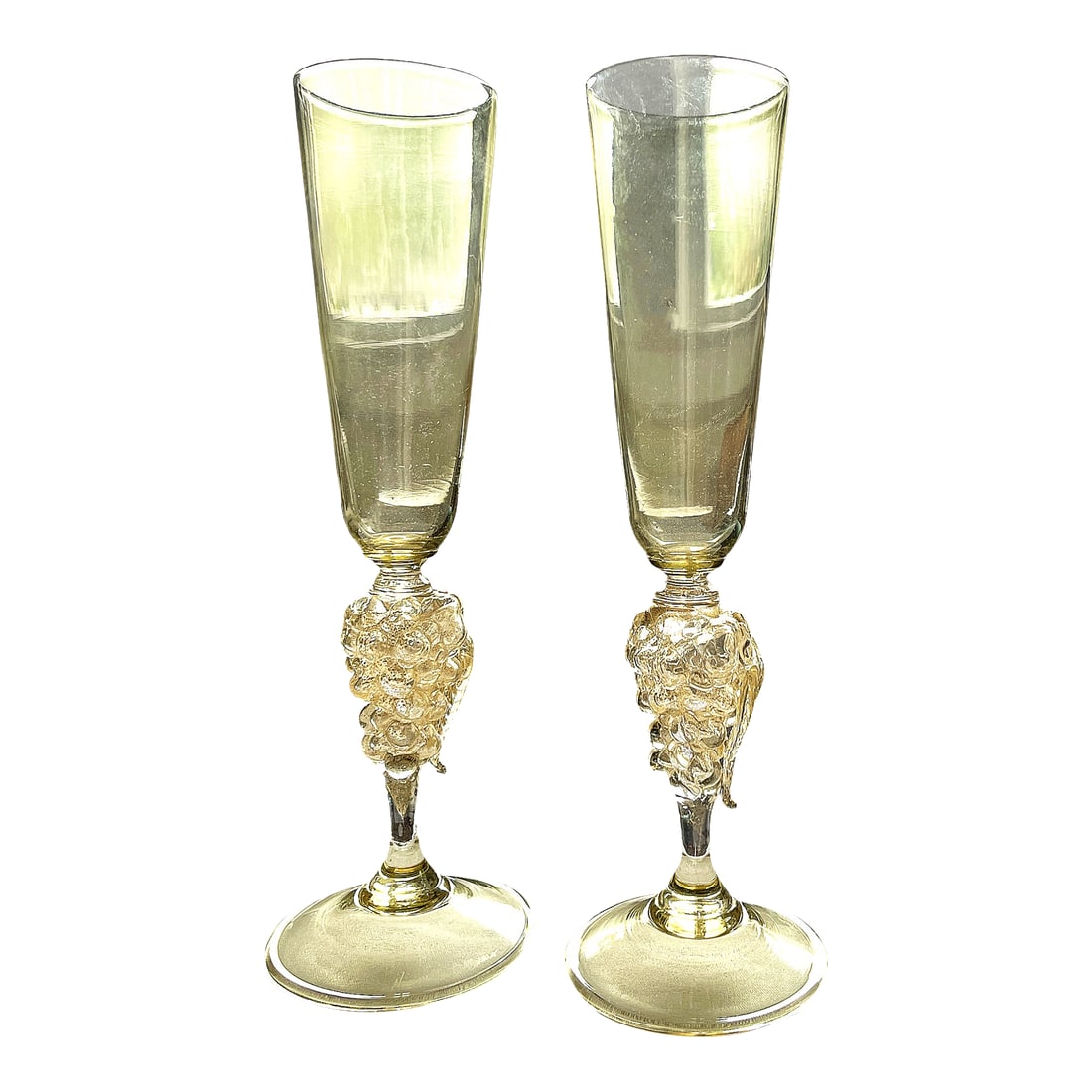 Vintage 1970s Signed Nason Moretti Murano Champagne Flutes With Grape Cluster Stems Gold Infused - A: An exquisite pair of signed Murano champagne flutes by Nason Moretti, one of Venice's most celebrated glassmakers. Each flute features a tall, tapered bowl in a delicate golden hue, rising from a rich