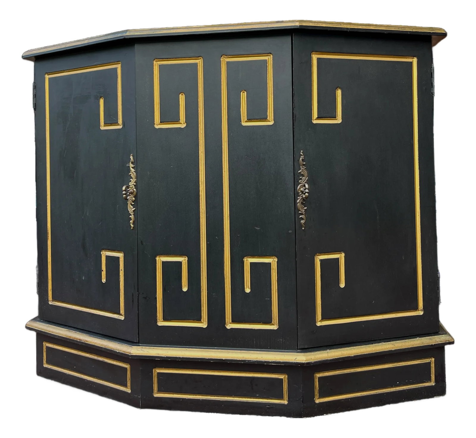 Hollywood Regency Black & Gold Trapezoid Credenza or Bath Vanity Cabinet in the Style of Dorothy Dra: A striking black, solid wood credenza with gilt Greek key detailing, this piece embodies the bold glamour of mid-20th century interior design. With its dramatic silhouette, gilt molding, and