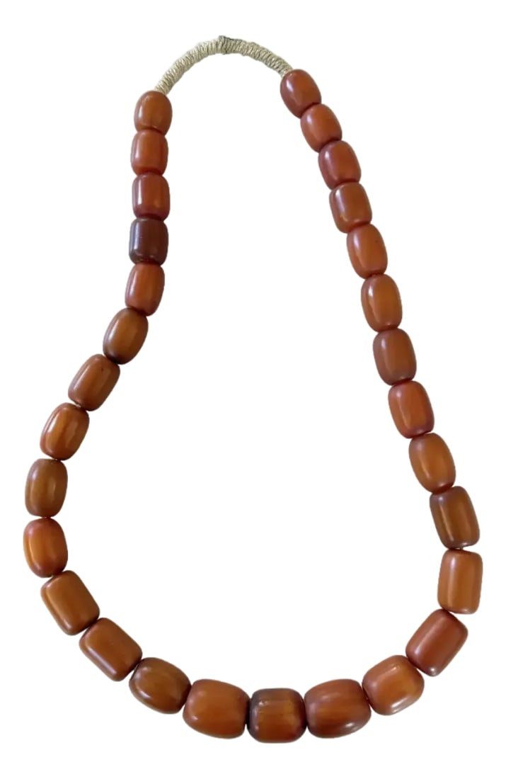 Vintage Copal Amber Beaded Necklace: Stunning collection of Antique Copal Amber beads strung on rope. Great necklace or add to your home decor collection. Condition: Alterations: Original Condition Unaltered Imperfections: Some Imperfect