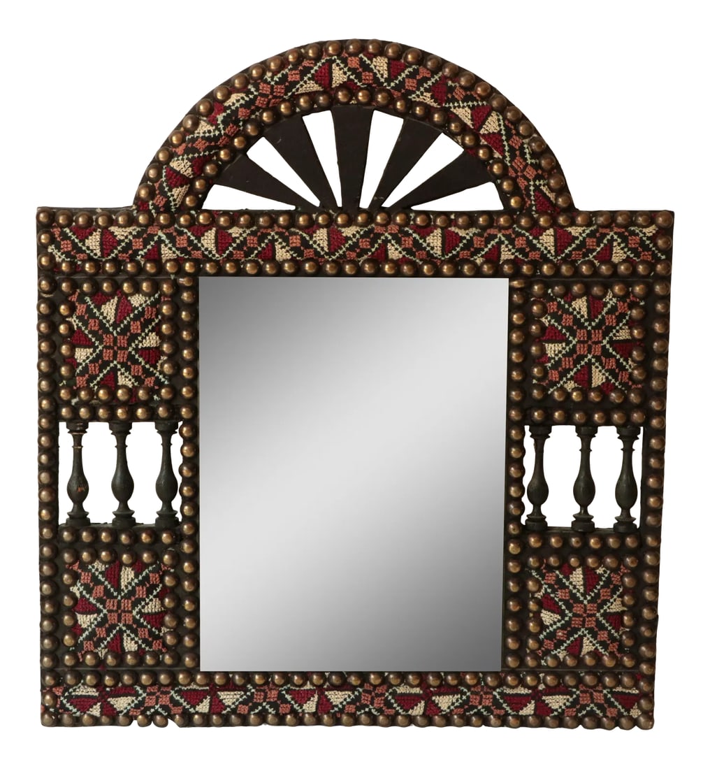 Tribal Cross Stitch Mirror With Nailhead Trim: Handmade arched wooden mirror, upholstered with hand stitched embroidery and accented with nailhead trim. Acquired in the Middle East in the early 1990's. It measures 16"W x 18" H x 3/4"D overall.