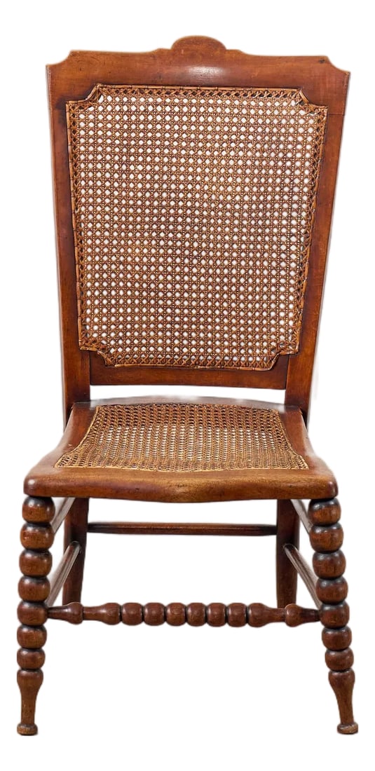 Antique Petite Walnut Accent/ Nursing Chair With Hand-Tied Cane Seat + Back With Bobbin Legs: This antique petite walnut accent chair features a hand-tied cane seat and back, set against a rich patinaed walnut frame, and sits on bobbin-turned front legs and a stretcher. A compact but unique ad