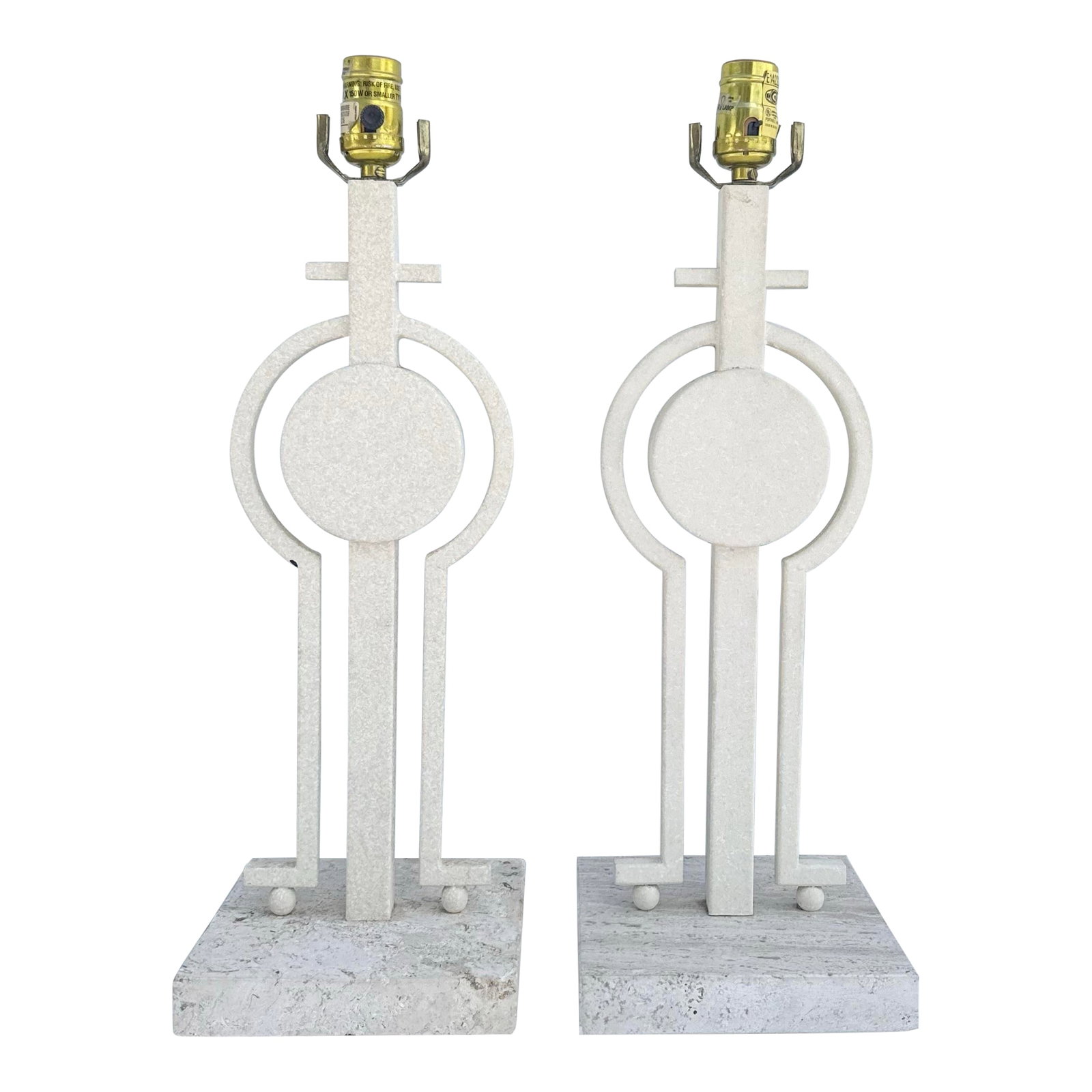 Mid Century Modern Sculptural Lamps on Travertine - A Pair: A striking pair of Mid-Century Modern sculptural table lamps showcasing bold geometric artistry and architectural influence. Crafted with creamy travertine bases and textured stone-like elements, the