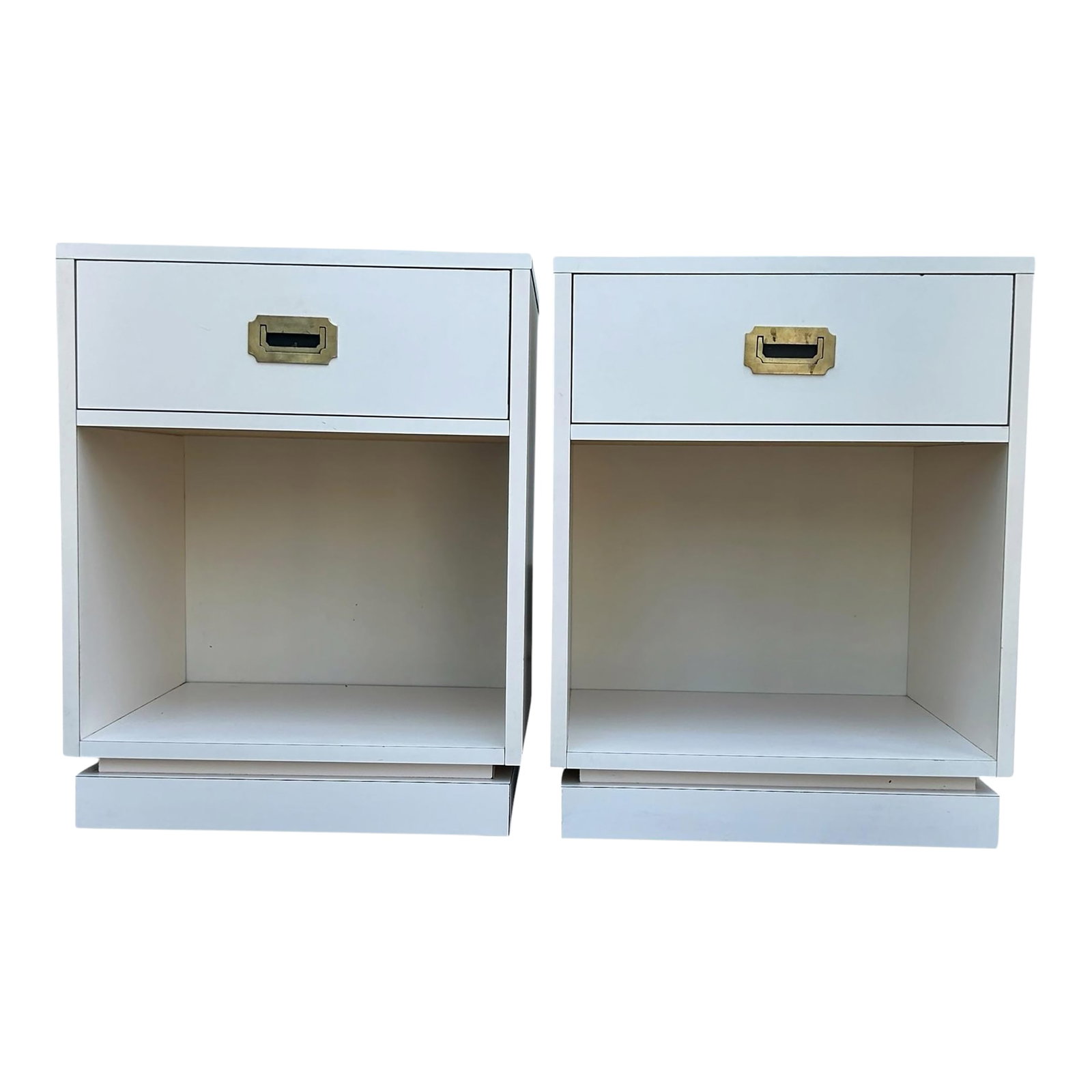 Pair of Vintage Campaign Style Bedside Tables: Pre- loved pair of white bedside tables. Campaign style with one drawer each and cubby space. They have brass hardware. They would be beautiful restored and lacquered. You could even use them as side 