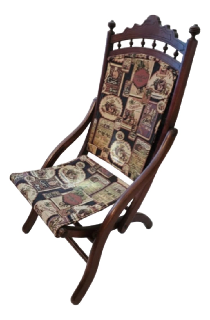 Late 19th Century Victorian Eastlake Carved Wood Folding Parlor Chair: A distinctive late 19th-century Victorian folding parlor chair featuring an unusually decorative carved wood frame and graceful reclining form. The tall back is crowned by an ornate carved crest