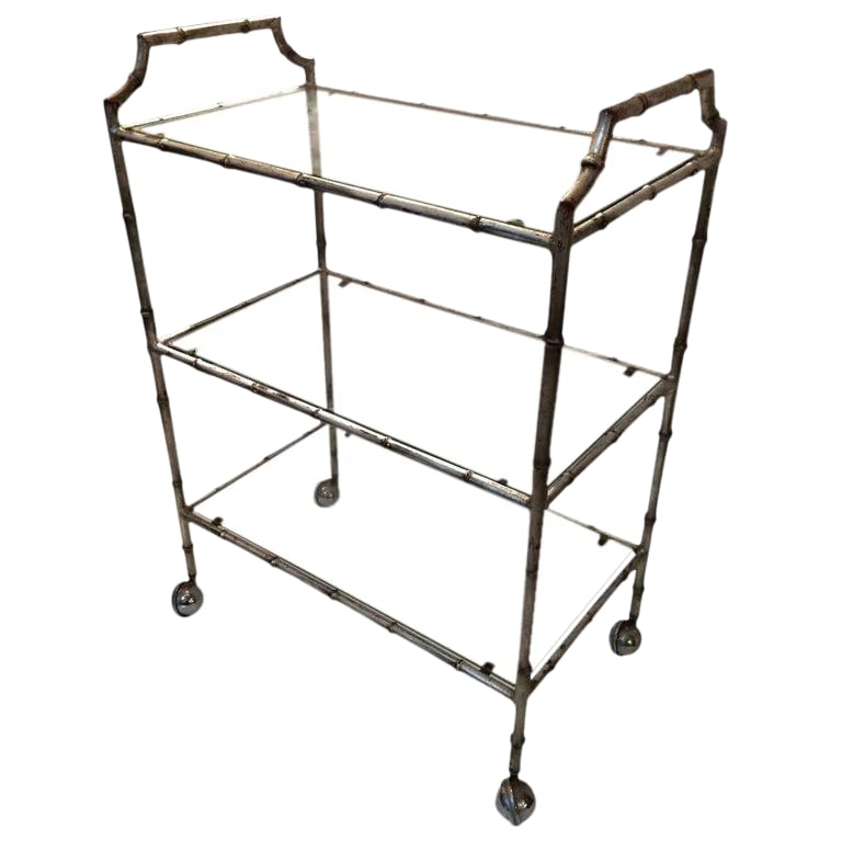 1960s Hollywood Regency Faux Bamboo Silverleaf Bar Cart: Very stylish iron faux bamboo bar cart having silver leaf coloration with reddish undercoat, offering an out of the ordinary three tiers and chrome ball casters for easy rolling. Condition: