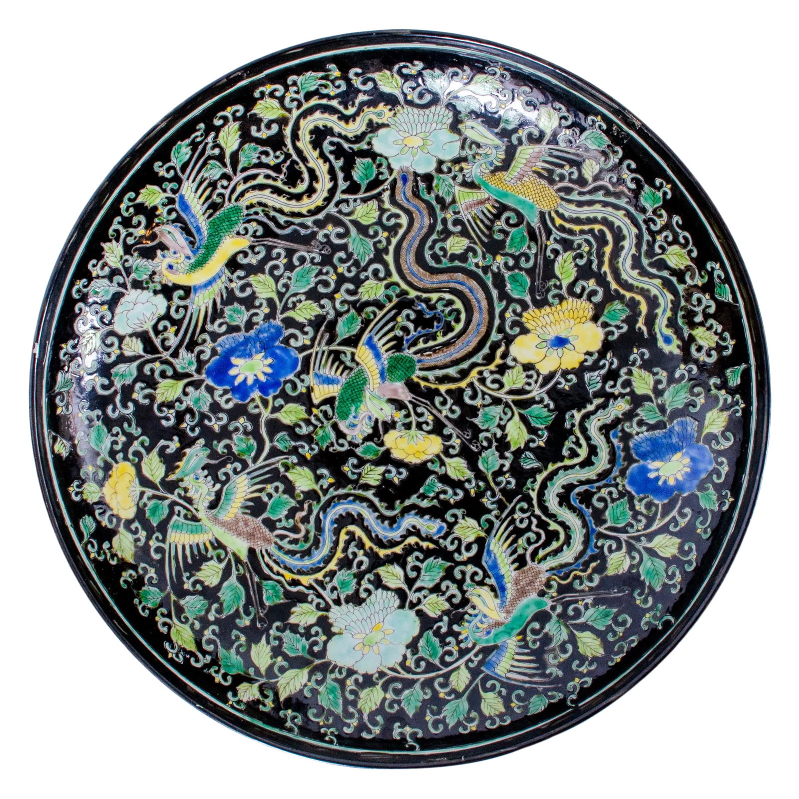 19th Century Kangxi Style Famille Noir Charger: A Kangxi style famille noir enameled charger decorated with phoenix in floral field. Six character Kangxi mark, 19th Century. 16 5/8 inches wide by 2 1/2 inches tall Condition: Alterations: Original C