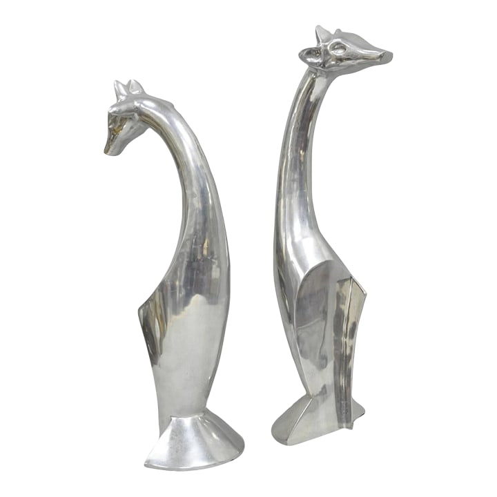 Late 20th Century Vintage Mid Century Modern Cast Aluminum Silver Giraffe Sculptures - A Pair: Vintage Mid Century Modern Cast Aluminum Silver Giraffe Sculptures (one a bit taller than the other) - a Pair. Circa Late 20th Century. Measurements: Tallest: 23" H x 7" W x 7" D. Condition: Alteratio