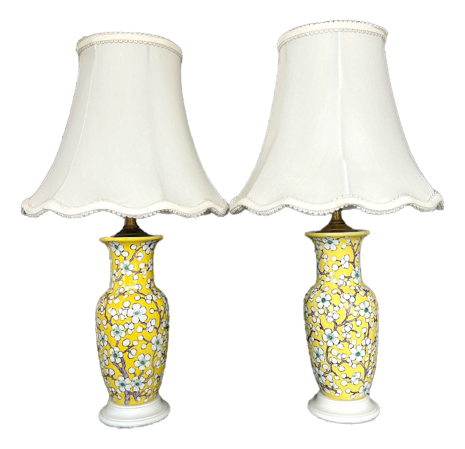 Vintage Yellow Porcelain Lamps Hand-Painted Cherry Blossom Design With Scalloped Ivory Shades a Pair: Pair of vintage table lamps with an elegant and timeless design. Each lamp has a curvaceous vase-shaped ceramic base, which tapers at the neck and flares slightly at the top before transitioning into 