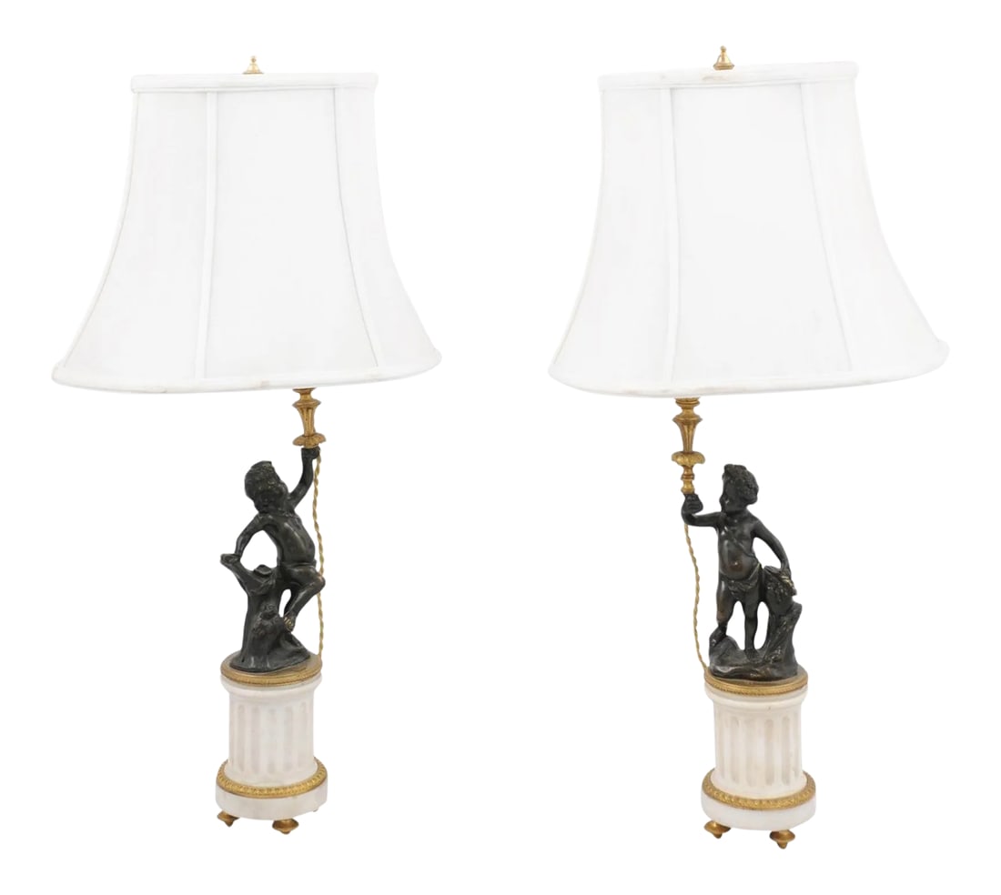 French 19th Century Neoclassical Style Marble and Bronze Putti Lamps - A Pair: A pair of French neoclassical style white marble and bronze putti lamps from the 19th century, with shades. Created in France during the 19th century, each of this pair of table lamps attracts our att