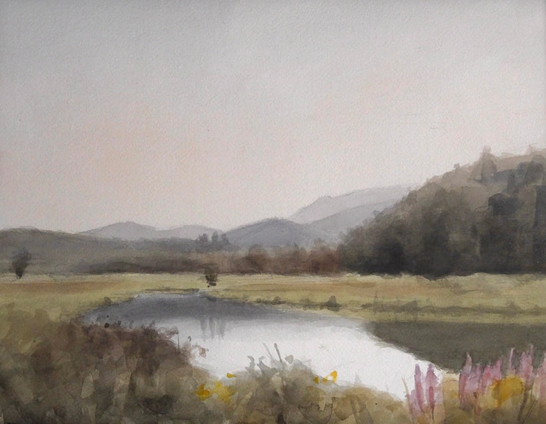 A Kind of Paradise by Mo Myra | Watercolor on Paper Landscape with a Pond and Mountains: A Kind of Paradise captures a serene landscape where gentle hills meet a tranquil pond, reflecting soft hues of the sky. The watercolor technique creates a delicate interplay of light and shadow,