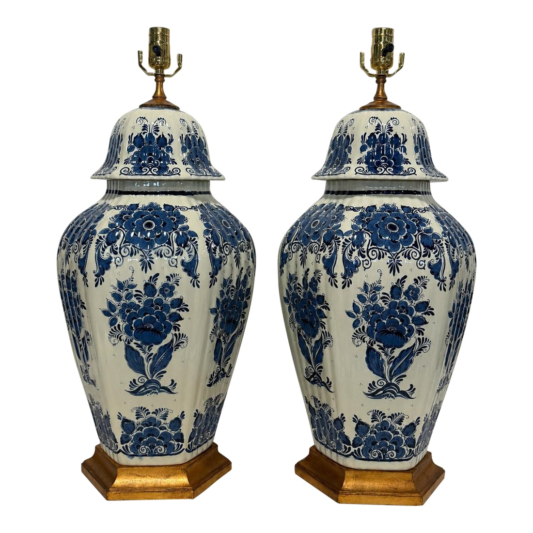 Mid-20th Century Dutch Delft Blue-and-White Ceramic & Giltwood Lamps - a Pair: A commanding pair of large blue-and-white covered-jar table lamps, Continental and probably Dutch, dating to the mid-20th century. Their substantial faceted bodies, architectural scale, and elaborate 