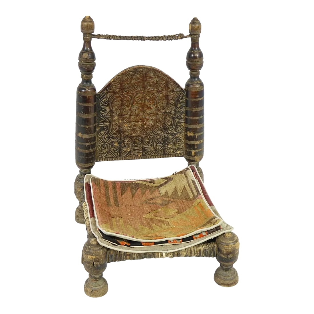 Late 19th Century Antique Middle Eastern Low Chair: This Antique Middle Eastern Low Chair is a beautiful example of traditional craftsmanship and design from the region. The chair features a distinctive low-profile design with a carved wooden backrest 