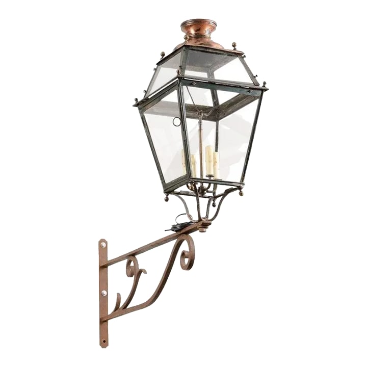 1890s French Iron and Copper Wall Lantern with Four Lights and Scrolling Bracket: A French iron wall lantern from the late 19th century, with four lights, glass panels, and scrolling bracket. Created in France during the last decade of the 19th century at a time when the