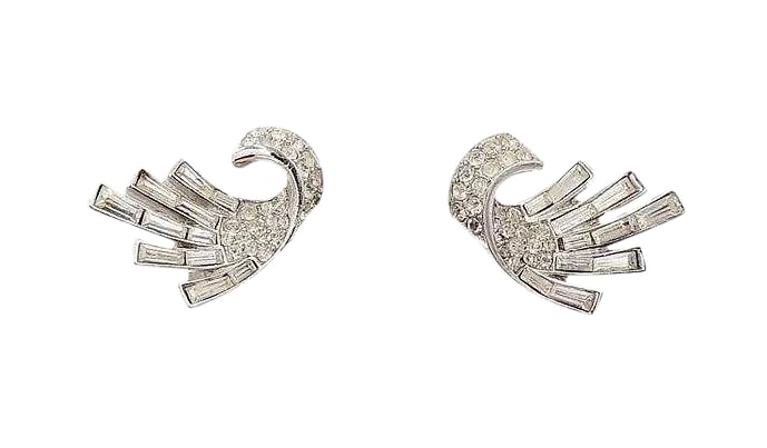 Vintage 1957 Crown Trifari Rhodium Plated Baguette Rhinestone Earrings - 2 Pieces: Rhodium plated baguette and round rhinestone clip back earrings. Marked "Trifari." Measure: 15/16 inches long by 15/16 inches wide. Condition: Very good; one baguette looks like a replacement. These