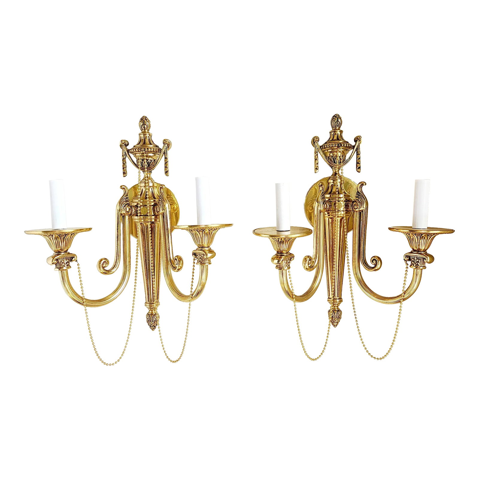 French Louis XVI Style Brass Wall Sconces-A Pair: Pair of French Louis XVI style (20th Century) solid and gilded brass wall sconces with fluted design, two scroll arms, an urn with swag finial top, and decorative beaded chain. Condition: Alterations: