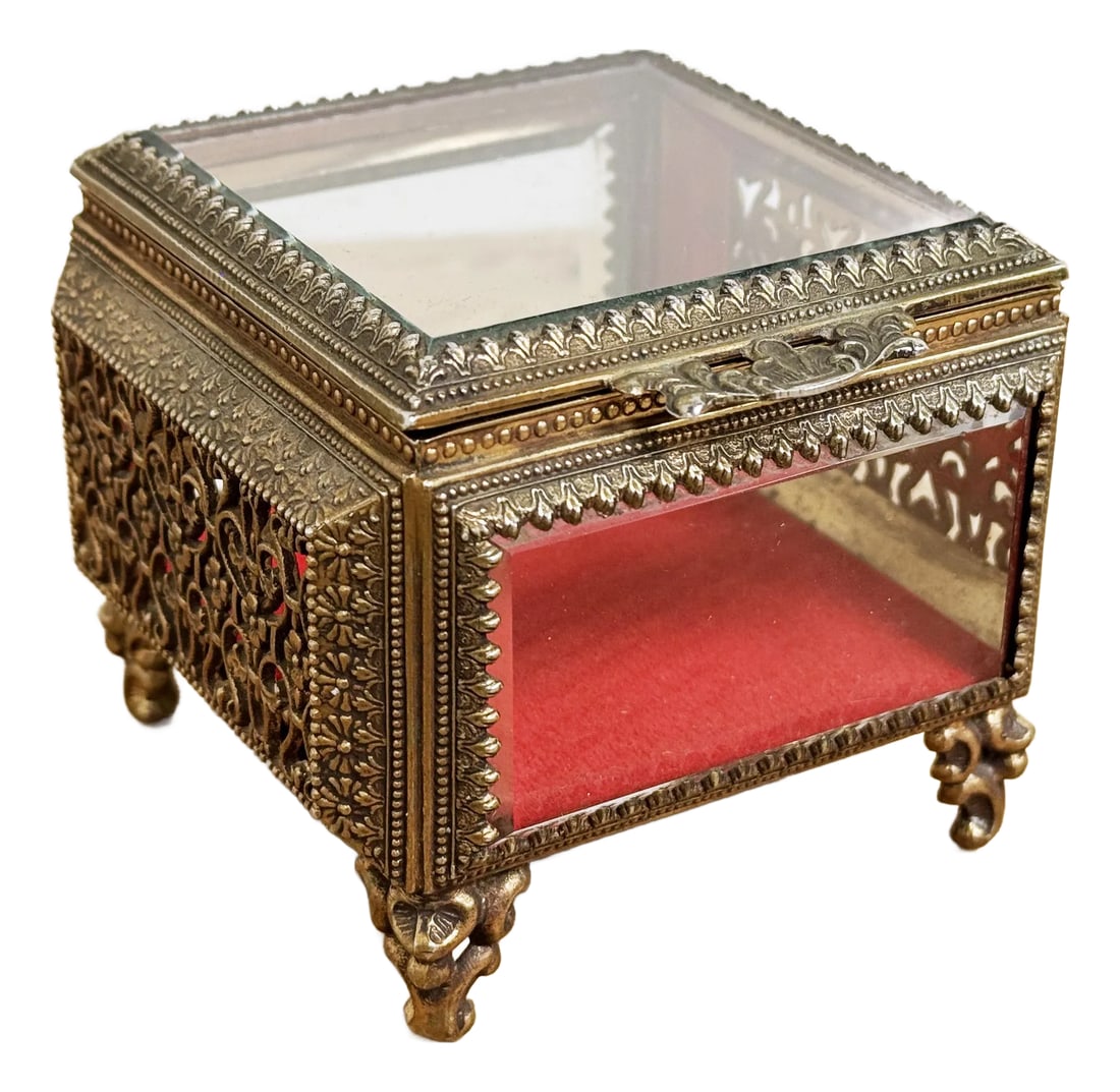 Vintage Ormolu Brass and Beveled Glass Jewelry Casket: Vintage bass jewelry box perfect for keeping your trinkets and jewelry safe! Lid offers a filigree design handle and beveled glass. Brass finish adds a touch of elegance while the red velvet lining
