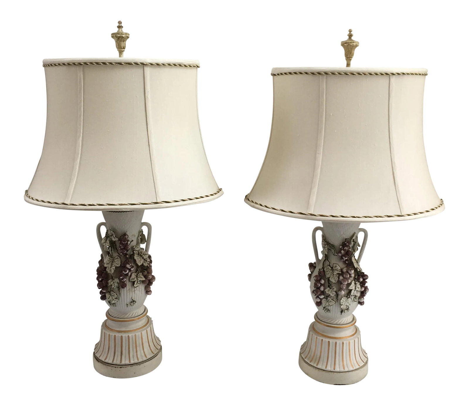 Vintage Italian Grape & Foliate Motif Porcelain Table Lamps - a Pair: Pair of Italian porcelain urn-shaped table lamps with hand-applied grape and leaf motif supported by metal bases. Silk shades with cording to rims included. Shades, 16" L x 12.25" W x 11" H; lamps,