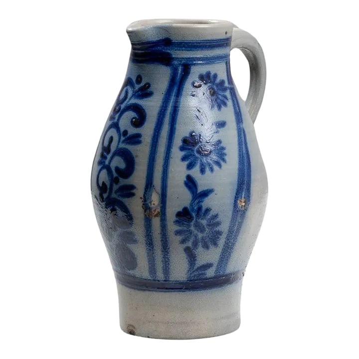 1900s Belgian Ceramic Jug: This 1900s Belgian ceramic jug is a splendid example of traditional craftsmanship, adorned with vibrant blue floral patterns that highlight its elegant form. The jug features a classic shape with a
