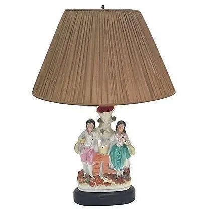Antique Jack & Jill Staffordshire Lamp: Antique; 19th century, Jack and Jill, English, Staffordshire, spill vase, table lamp. A spill vase converted into a lamp depicts the storybook characters Jack and Jill. Ebonized wood base. Brass wire