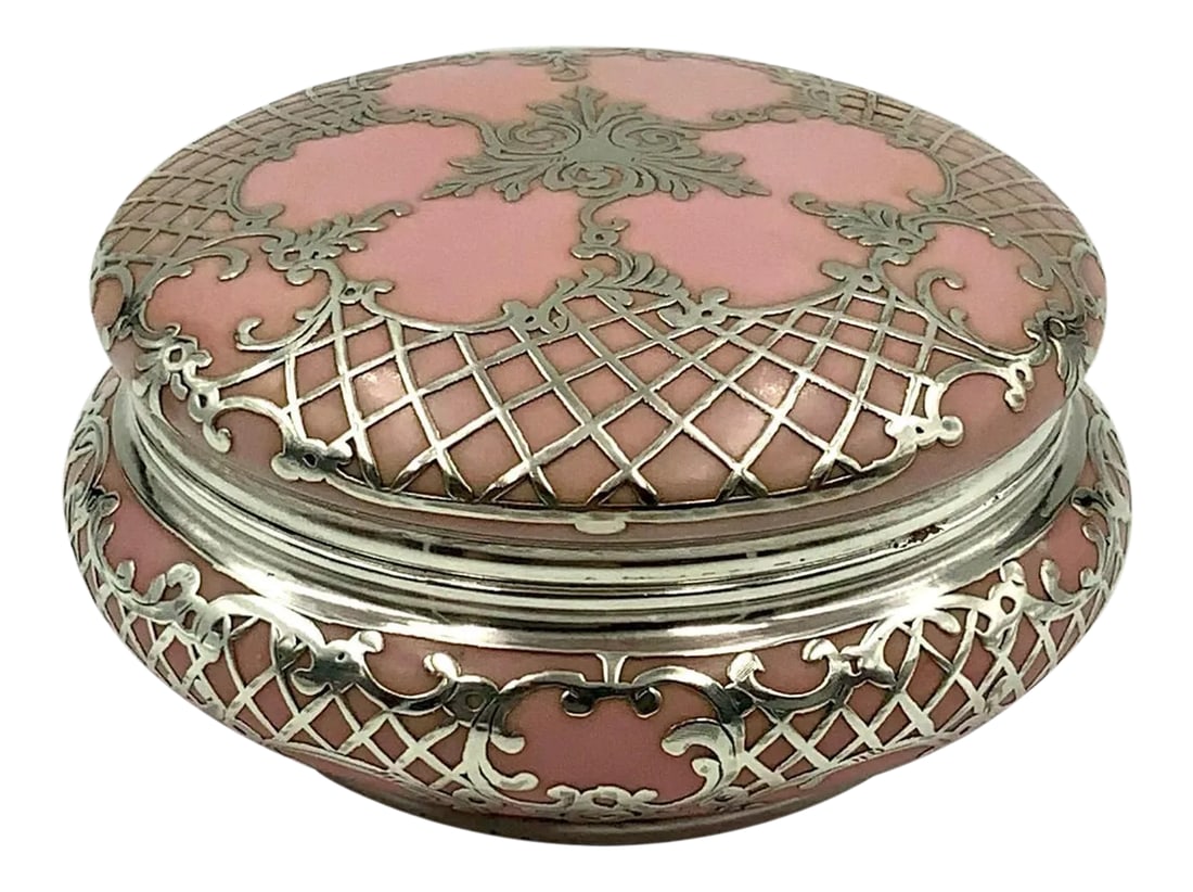 Antique Sterling Silver Pink Porcelain Vanity Powder Jar Trinket Box: Gorgeous trinket box or powder jar featuring an ornate scroll and lattice design sterling silver overlay over a pretty pink porcelain. The mark on the bottom is not legible. Condition: Alterations: