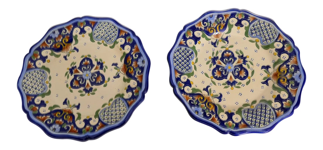 French Hand-Painted Faience Plates - A Pair: Set of two hand-painted decorative faience plates from Rouen, France. Painted in dark blue, light blue ,green, and rust on a cream background. Condition: Alterations: Original Condition Unaltered