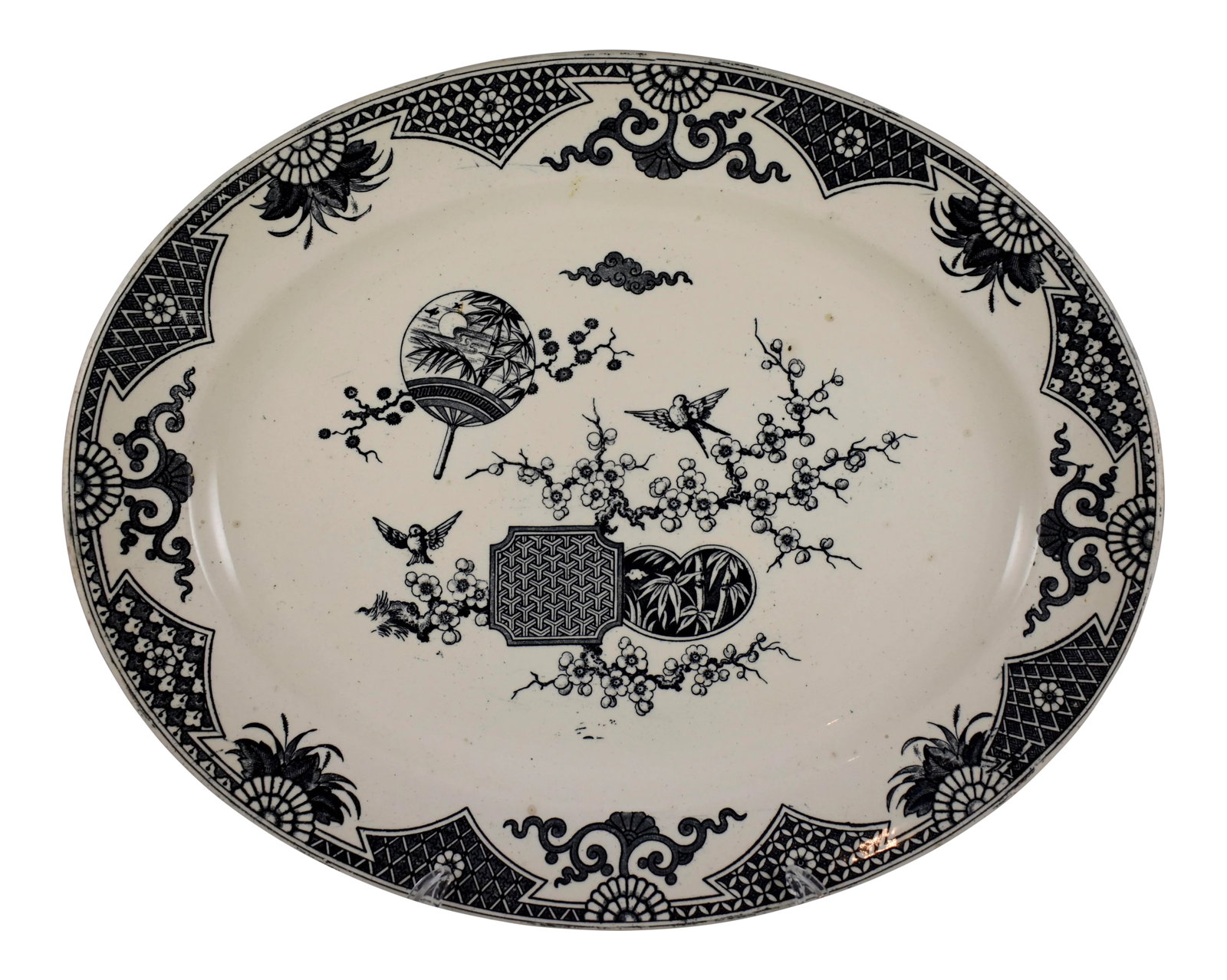 English Aesthetic Movement Transferware Formosa Staffordshire Serving Platter: A large Aesthetic Movement platter, Thomas Furnival & Sons, Cobridge, Staffordshire, England, circa 1879. The Japanesque 'Formosa' pattern is transfer printed in black on a cream earthenware body and 